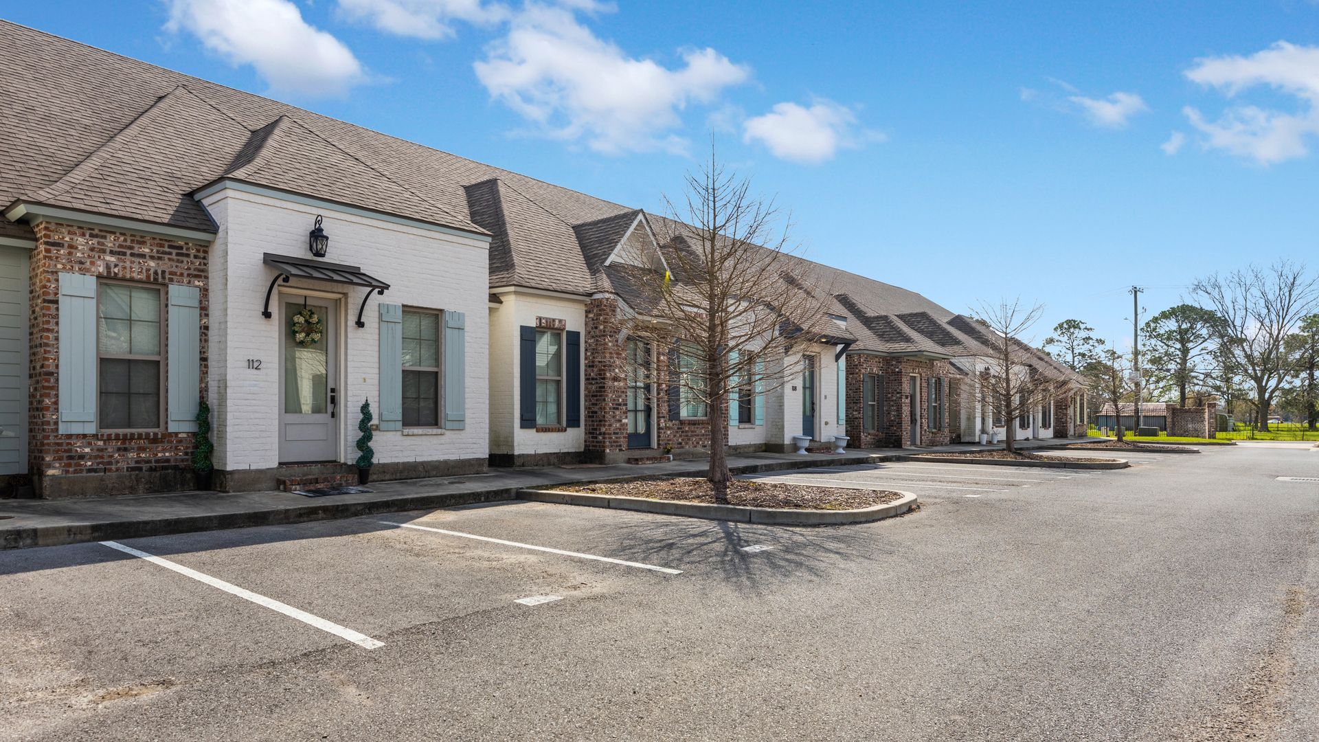 A row of houses with a parking lot in front of them.