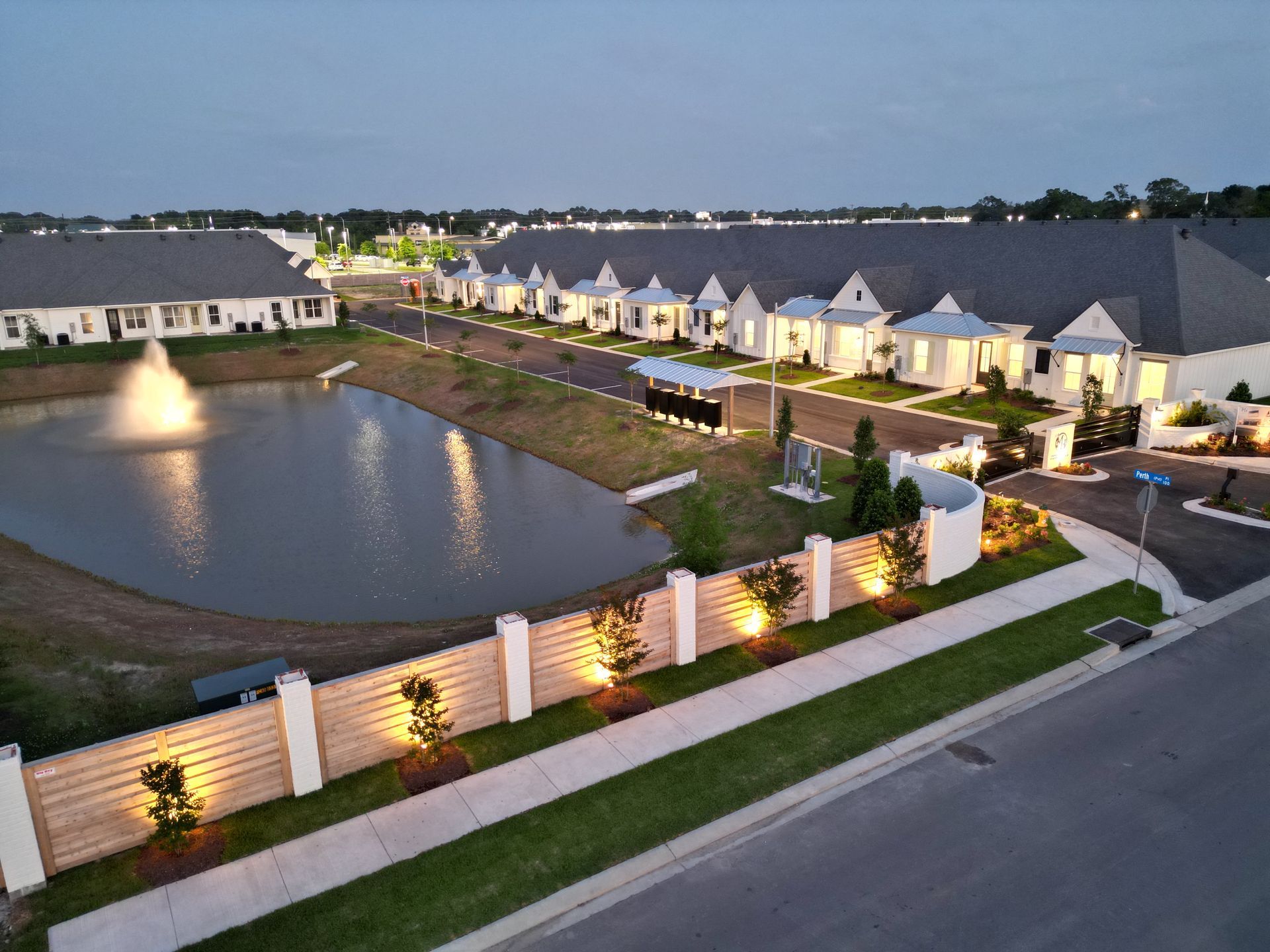 An aerial view of a row of houses with a pond in the middle