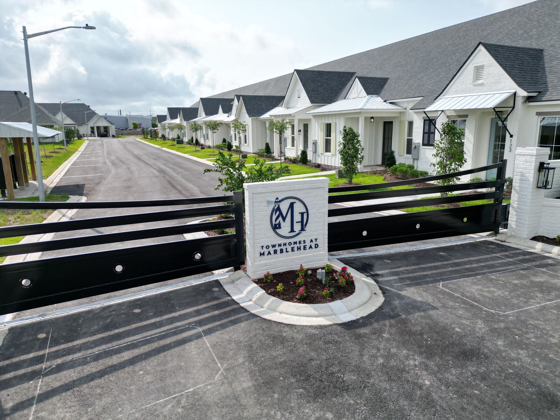 A gated entrance to a residential area with a sign that says ' a ' on it.