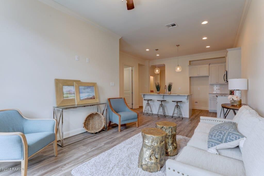 A living room with a couch , chairs , and a ceiling fan.