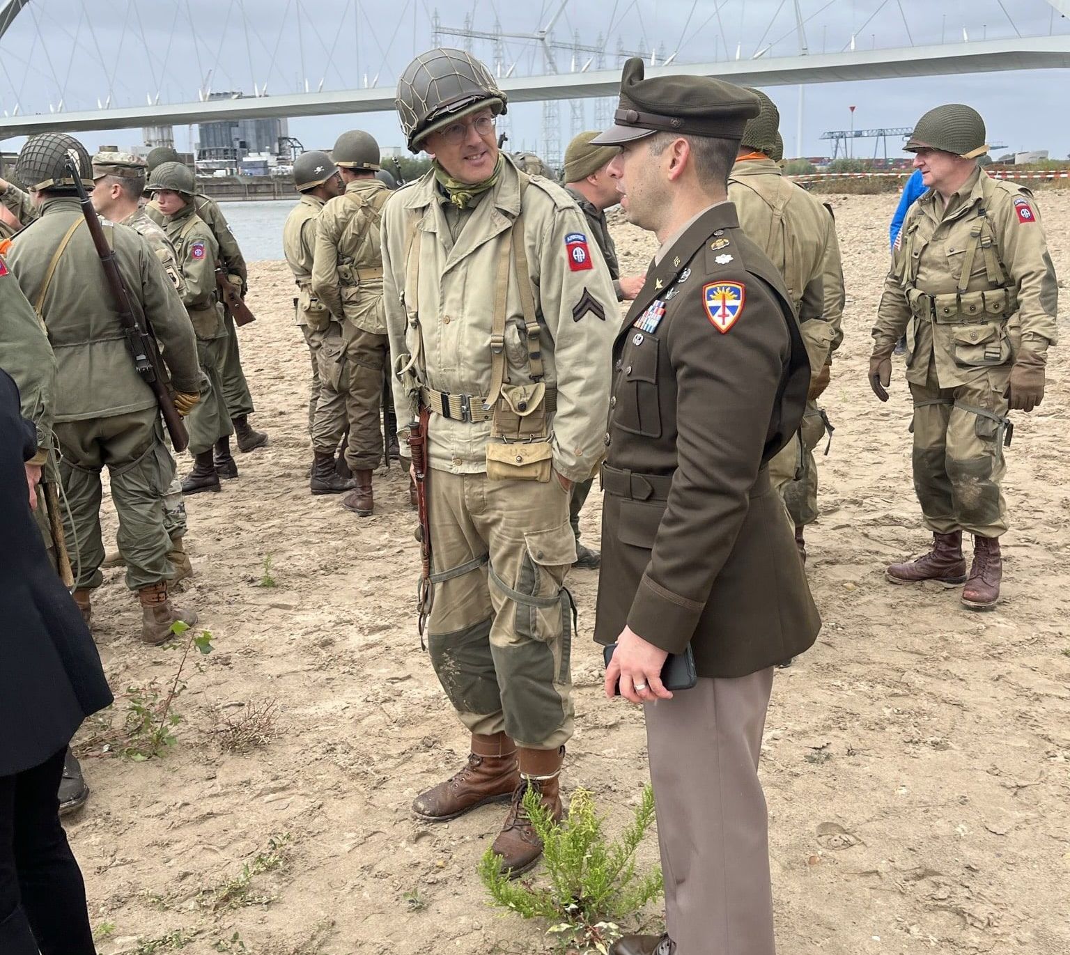 Een groep soldaten staat in een veld met elkaar te praten.