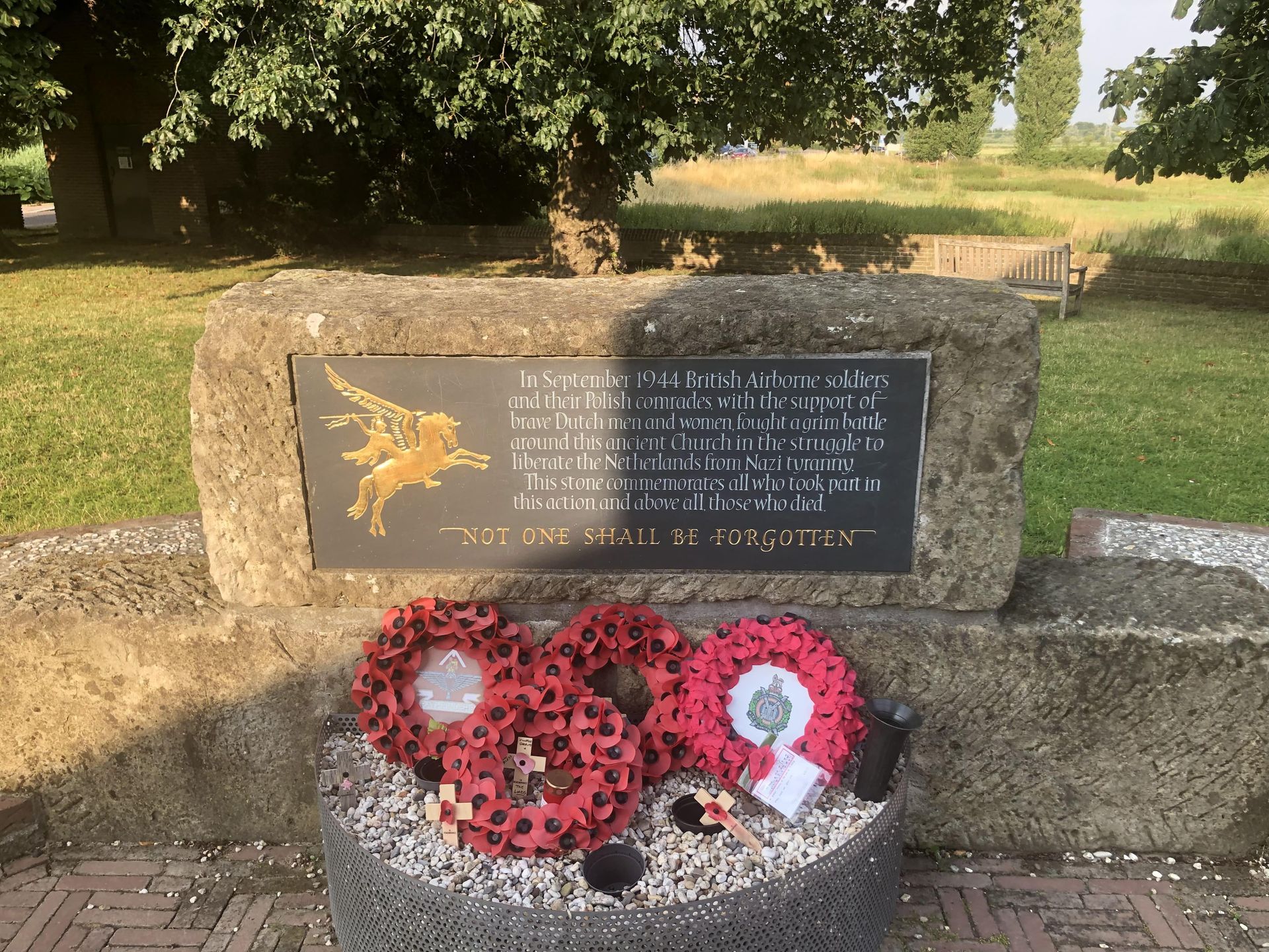 A memorial with a plaque and wreaths on it