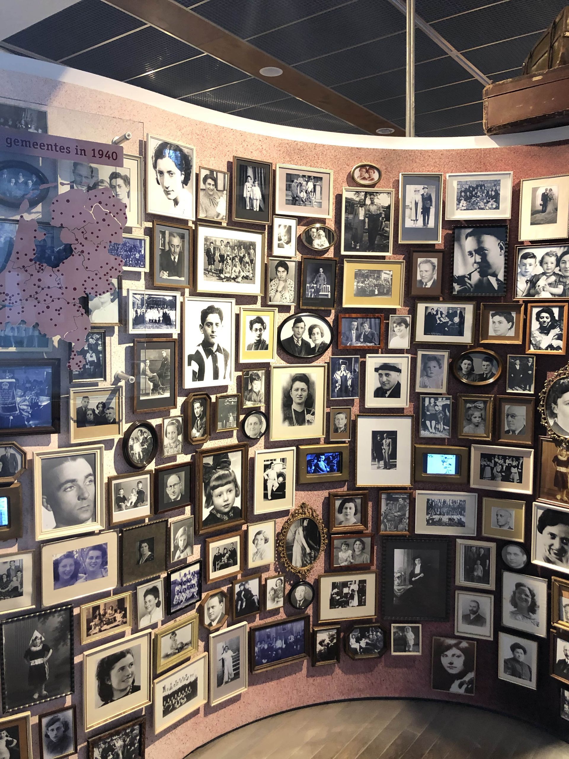 A wall with a lot of framed pictures on it