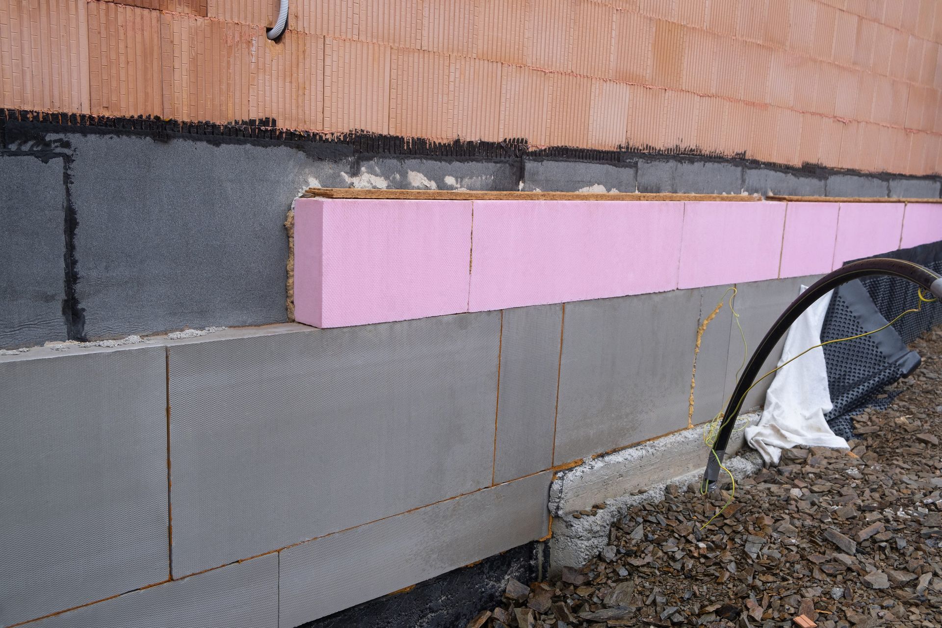 A pink foam block is being installed on the side of a building.