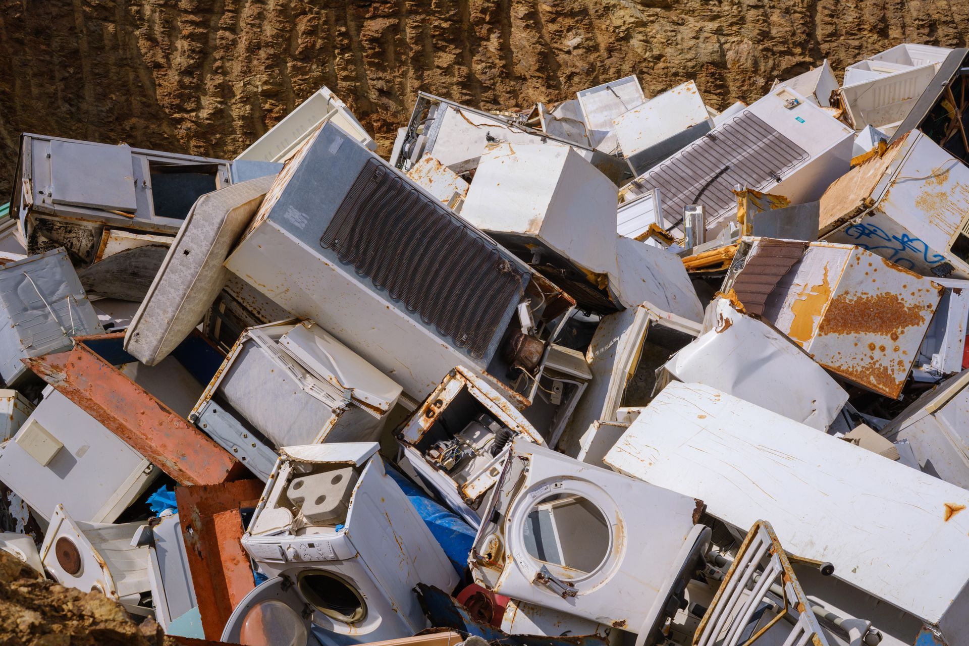 Pile of discarded household appliances stacked in a landfill. Pile of discarded household appliances stacked in a landfill.