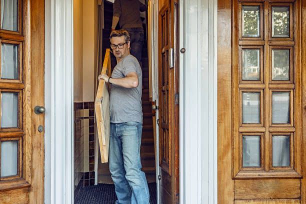 Professional moving worker carrying items, representing reliable furniture removal during daytime.