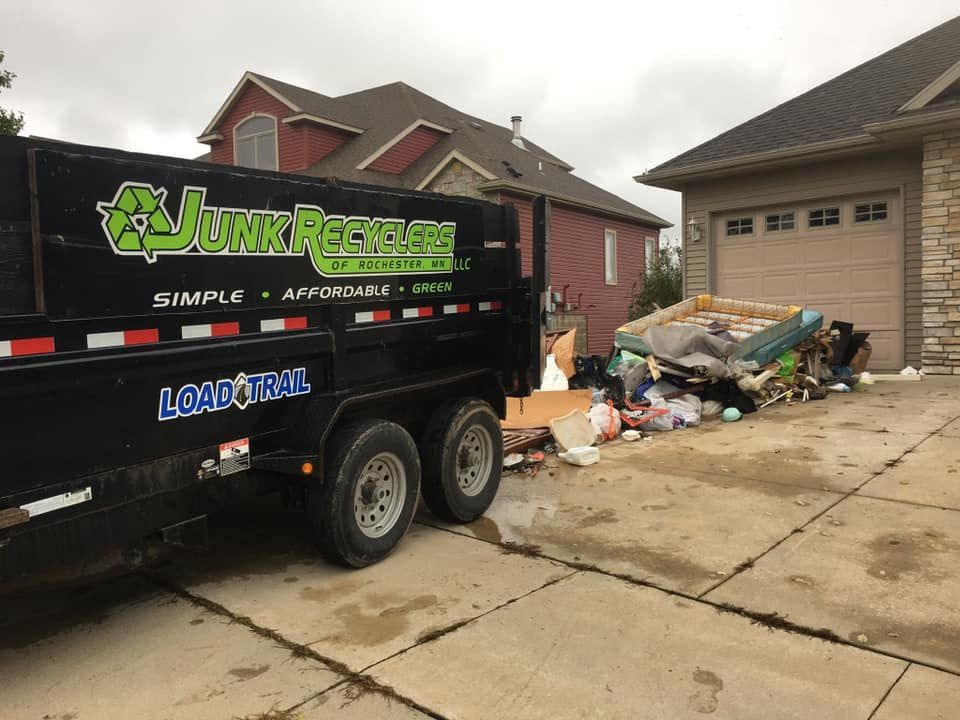 A removal truck with its ramp down, loaded with furniture and debris