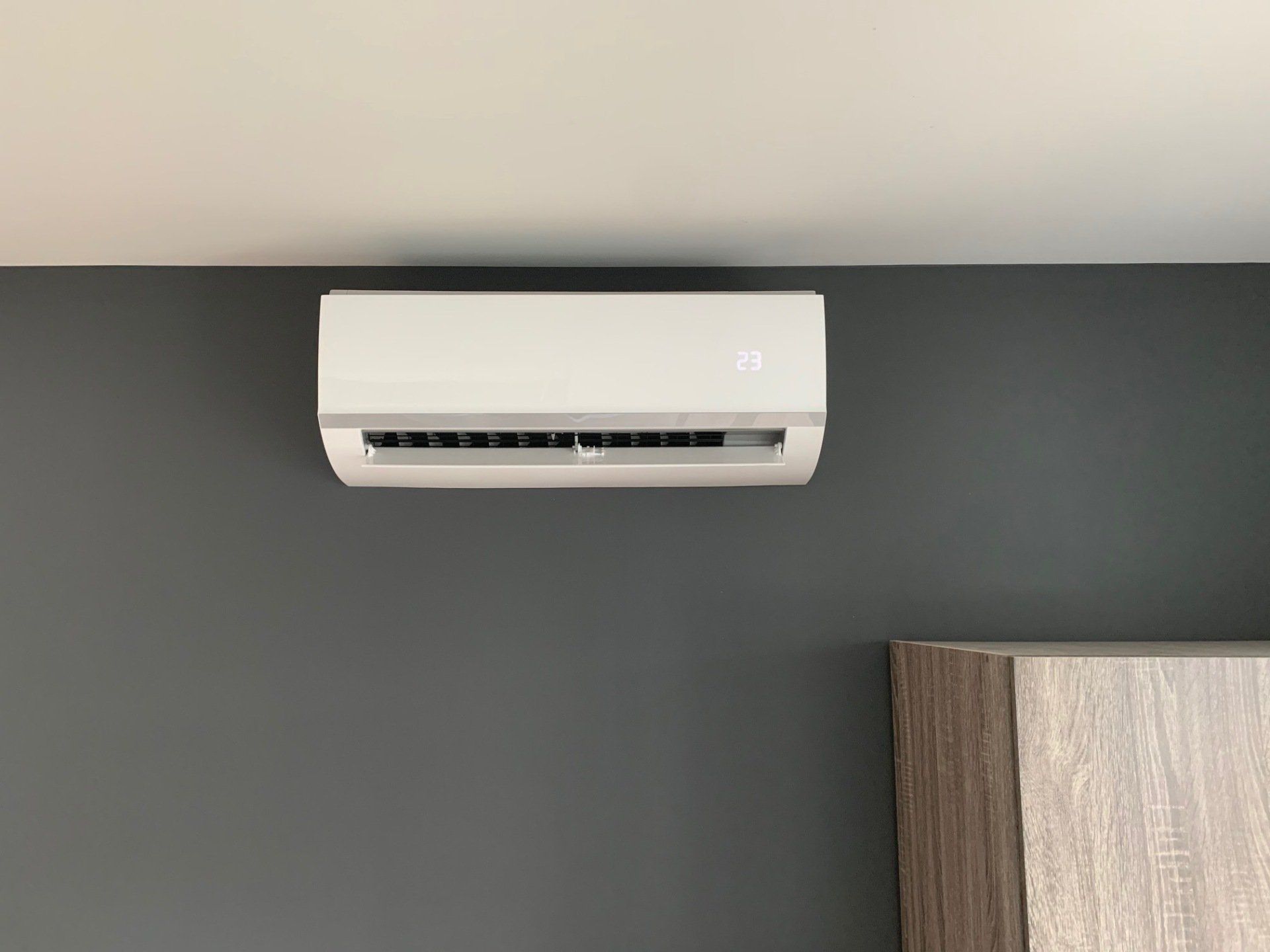 Un climatiseur blanc est accroché au mur d'une pièce.