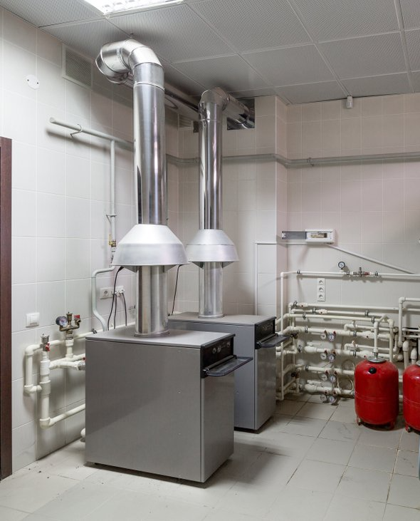 Deux chaudières sont placées dans une pièce l'une à côté de l'autre.