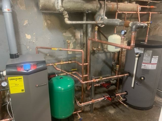 Une pièce avec beaucoup de tuyaux et un chauffe-eau.