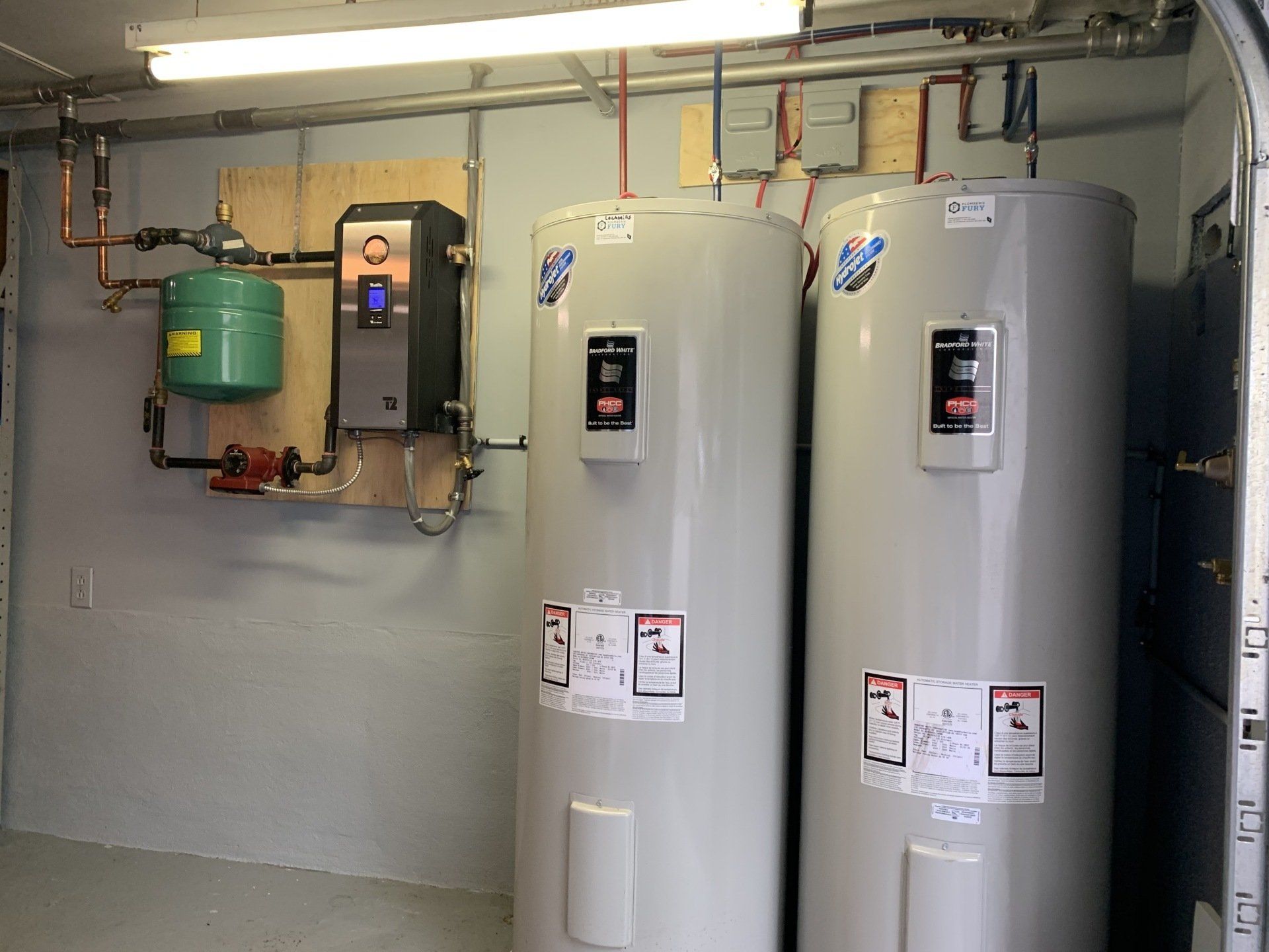 Deux chauffe-eau sont placés l'un à côté de l'autre dans une pièce.