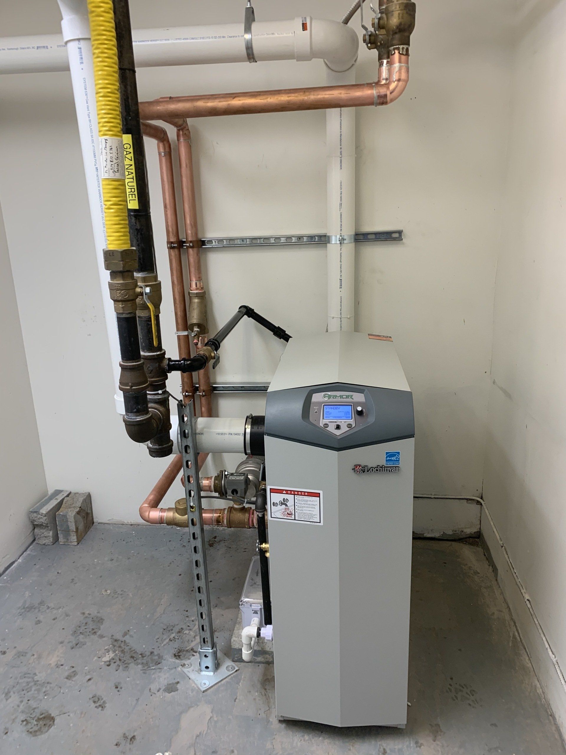 Une chaudière est installée dans une pièce avec des tuyaux qui en sortent.