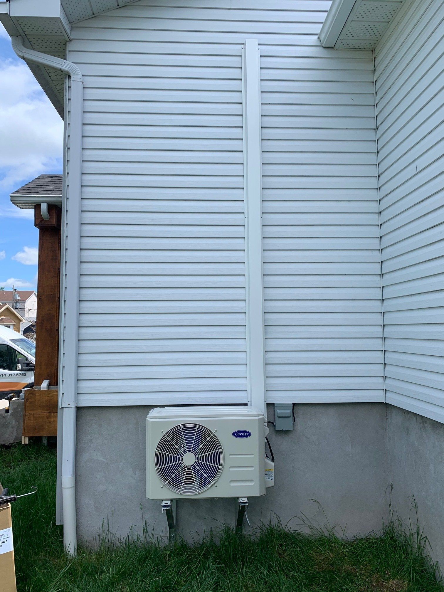 Une maison blanche avec un ventilateur sur le côté.