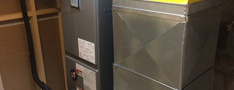 Un climatiseur est installé dans une pièce à côté d'un réfrigérateur.