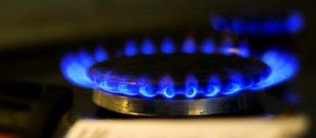 Un gros plan d'un brûleur à gaz avec des flammes bleues.