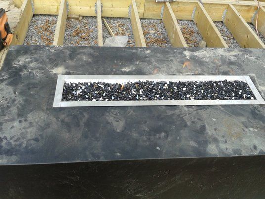 Un foyer est en cours de construction sous une terrasse en bois.