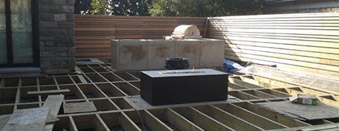 Une terrasse en bois est en cours de construction devant une maison.