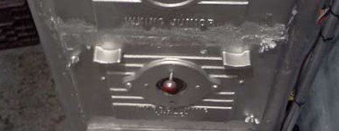 Un gros plan d'un objet métallique avec une boule rouge à l'intérieur.