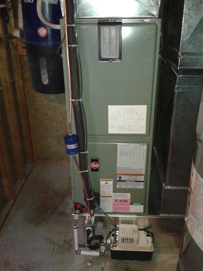 Un climatiseur est installé dans un sous-sol à côté d'un chauffe-eau.