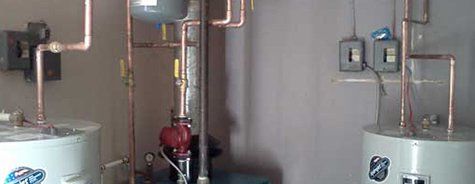 Deux chauffe-eau sont placés l'un à côté de l'autre dans une pièce.