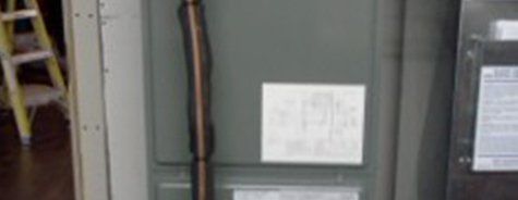 Une échelle est posée à côté d'un réfrigérateur dans une pièce.