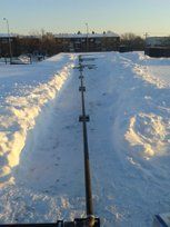 Un toit enneigé avec un tuyau au milieu.