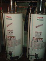 Deux chauffe-eau sont assis l'un à côté de l'autre dans un sous-sol.