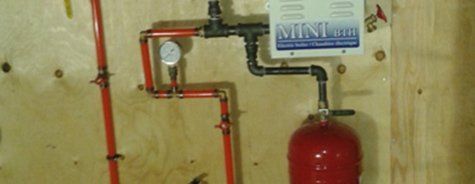 Un réservoir rouge est attaché à un mur avec des tuyaux rouges.