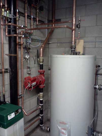 Une pièce avec un chauffe-eau et des tuyaux en cuivre