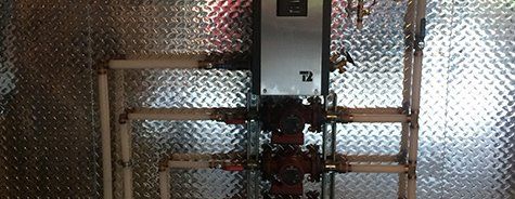 Une pièce avec un mur en métal et des tuyaux à l'intérieur.