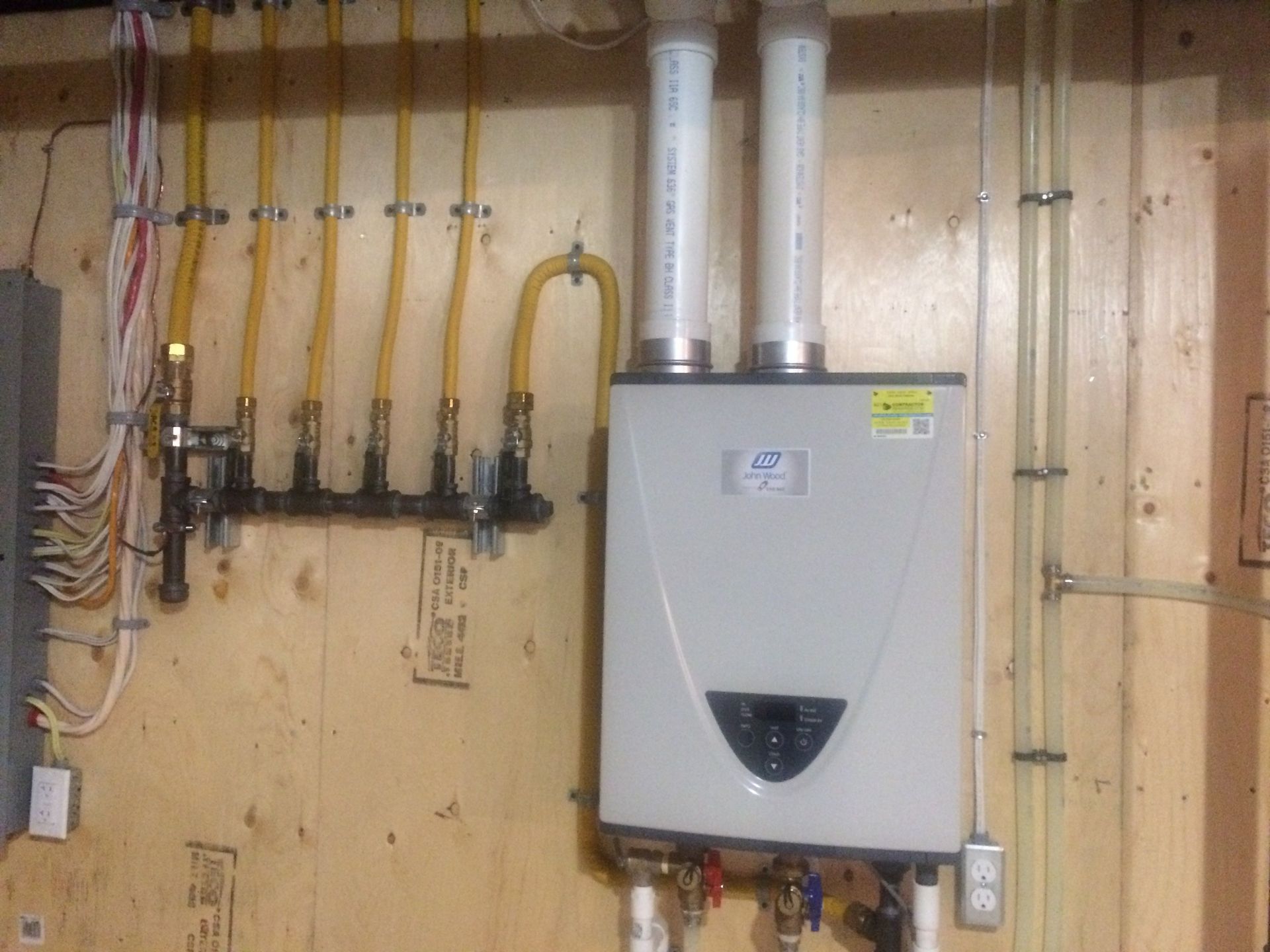 Une chaudière à gaz est accrochée au mur d'une maison.