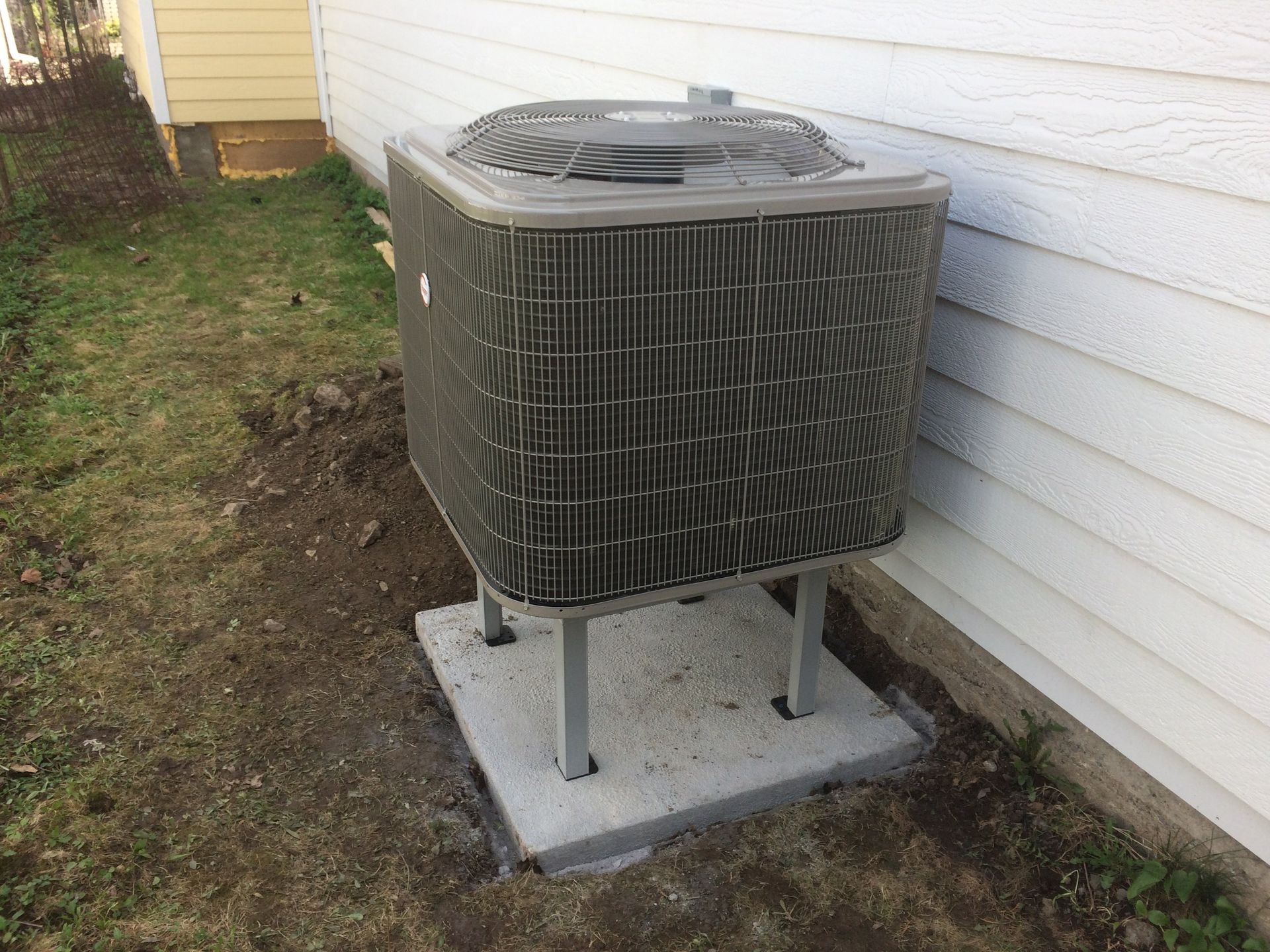 Un grand climatiseur est installé à l'extérieur d'une maison.