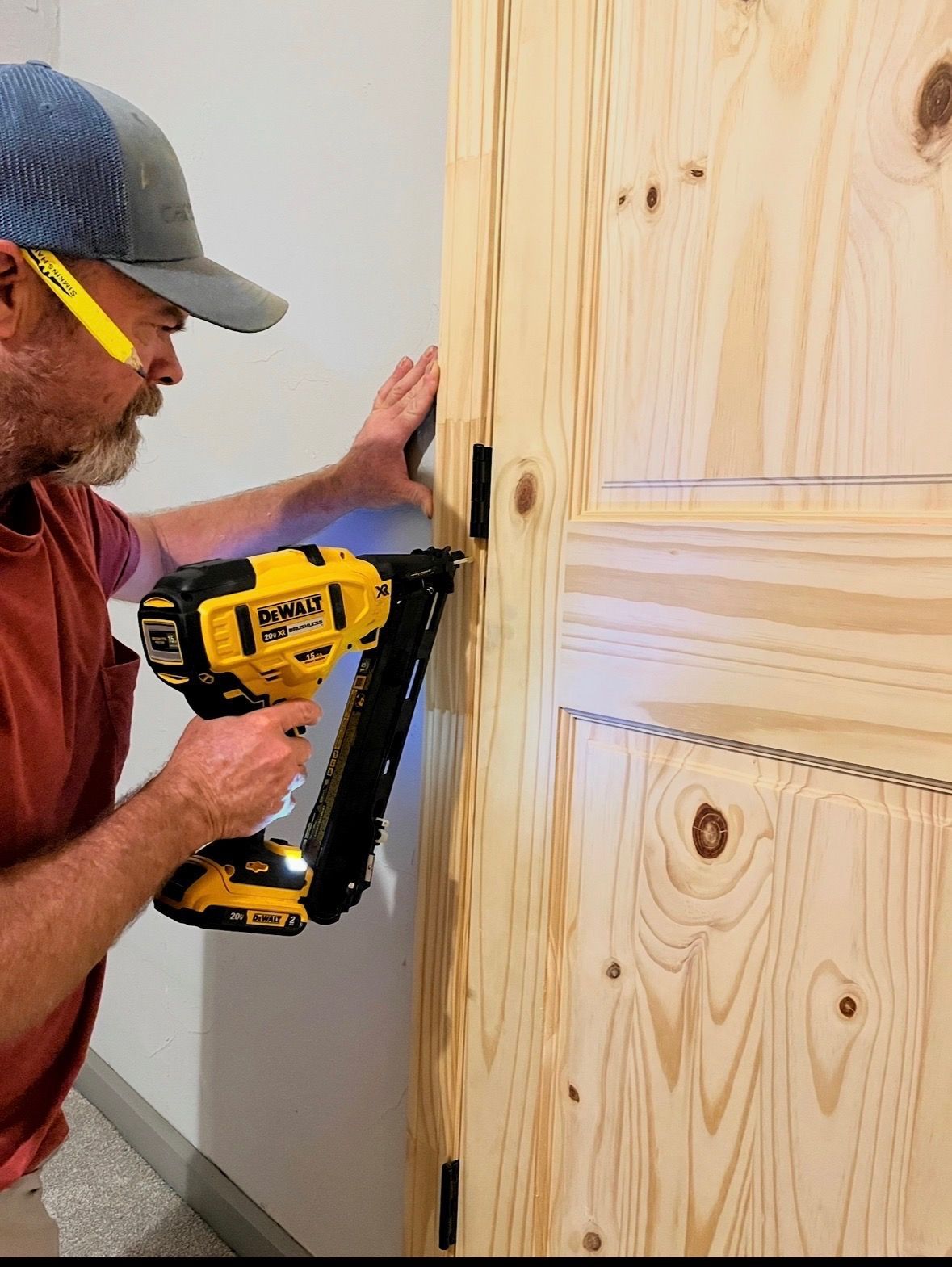 A person is fixing a door lock with a screwdriver.