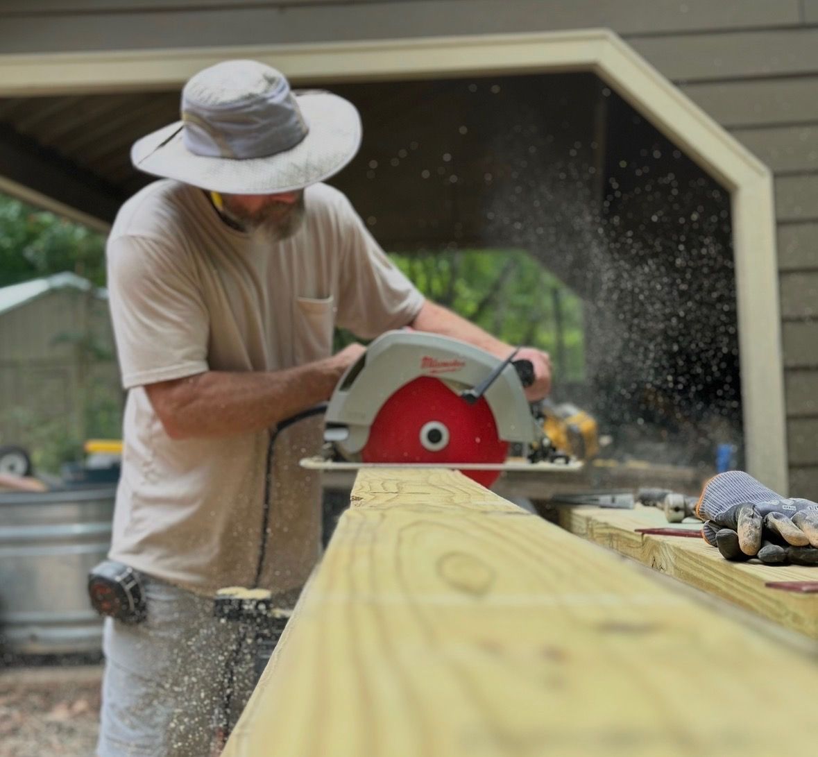 A man is using a circular saw to cut a piece of wood.
