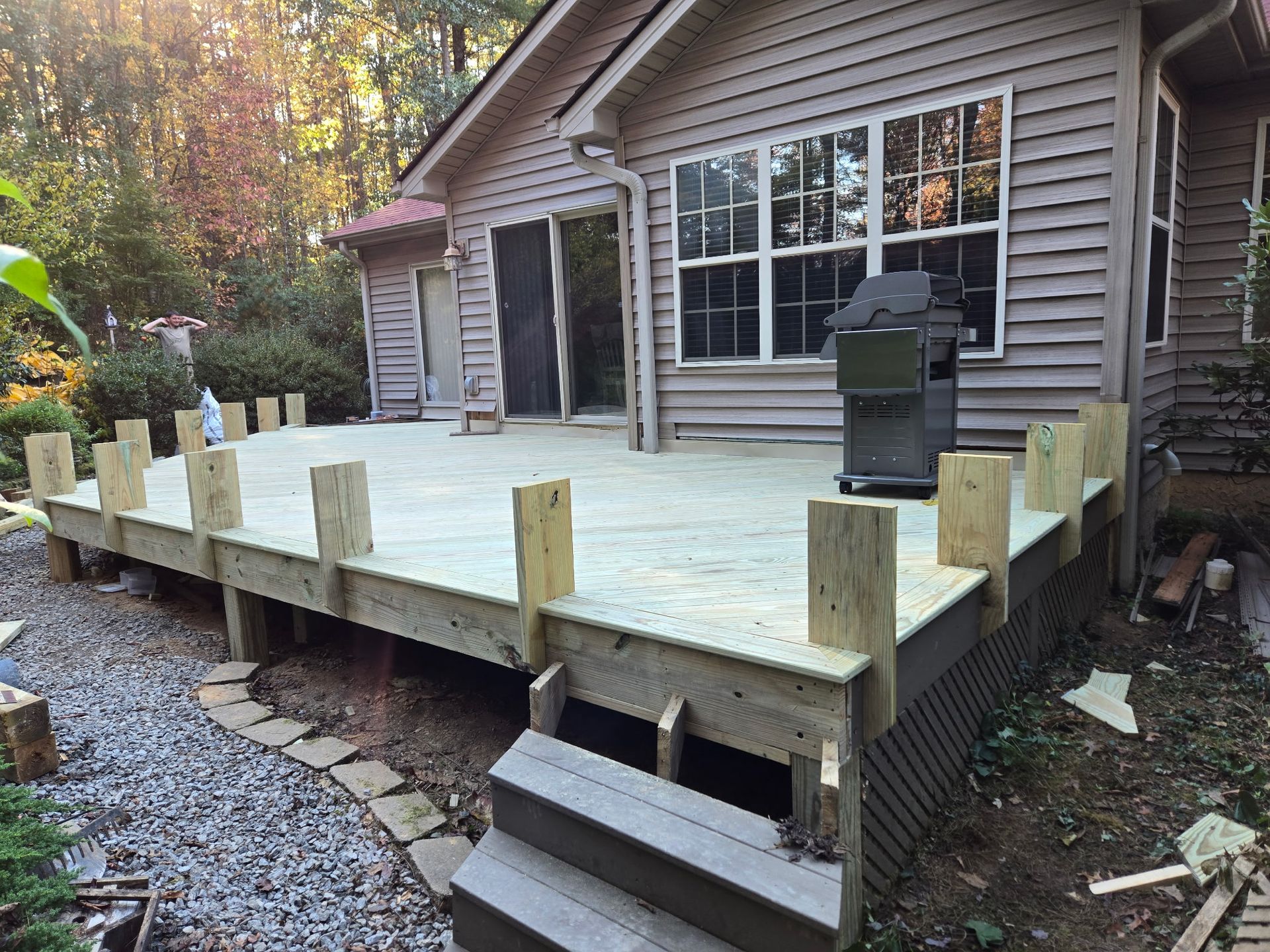 A large deck with a couch , chairs , and a table.