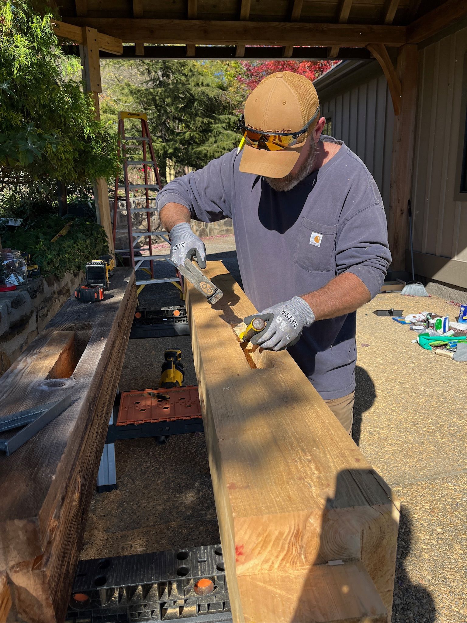 A man wearing a camouflage hat is working on a pipe