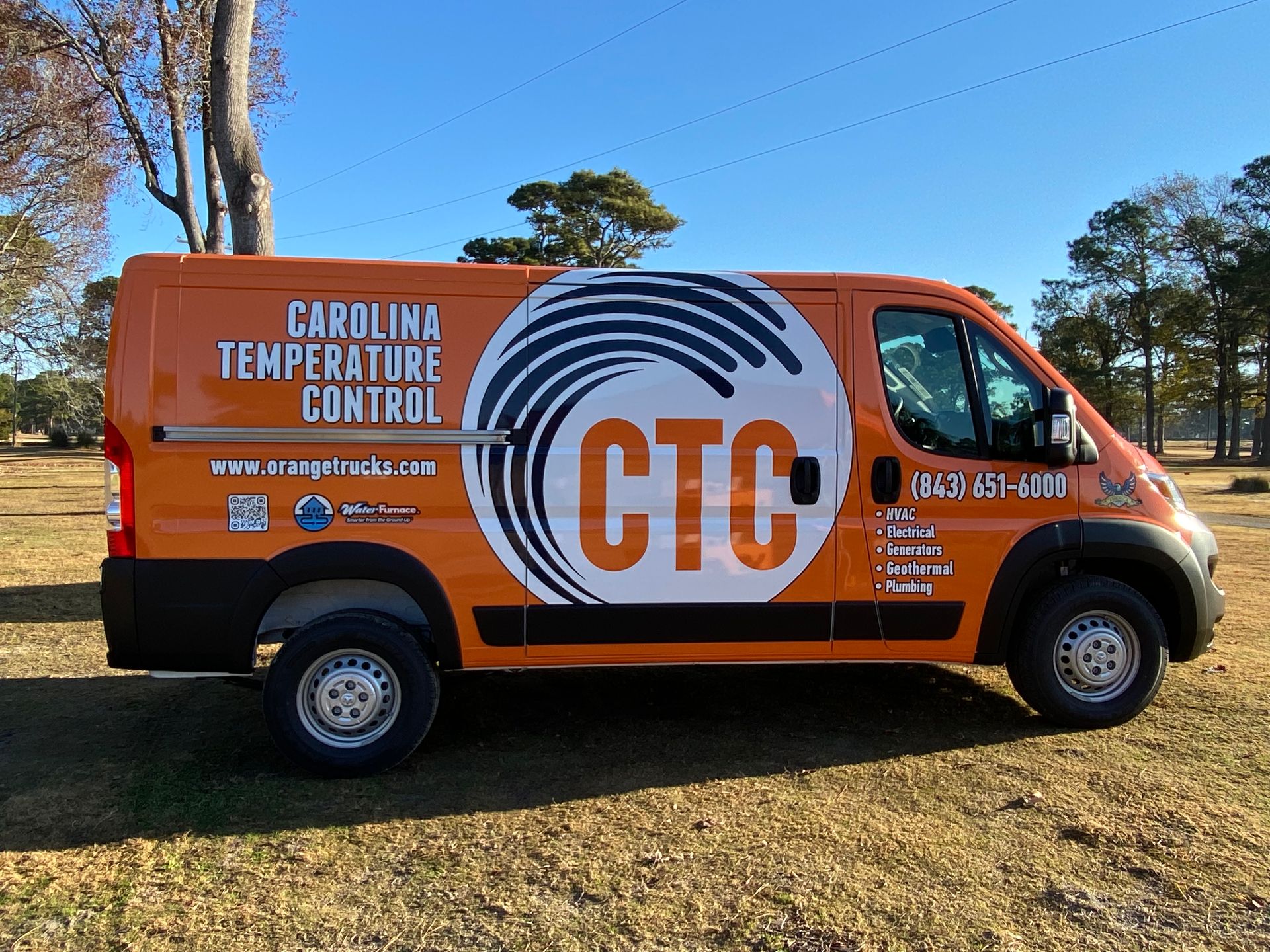 Orange Carolina Temperature Control van parked on grass.