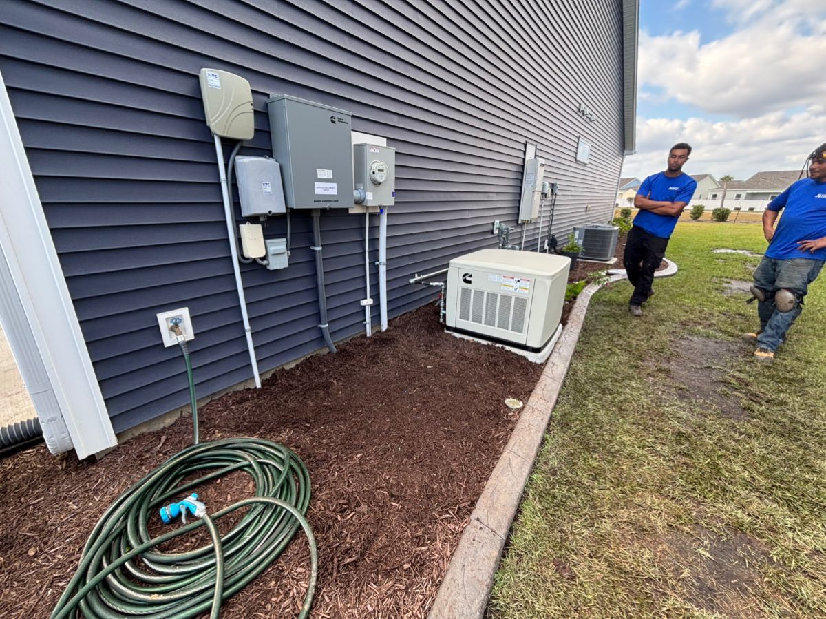 Two CTC electricians installing a Cummins generator