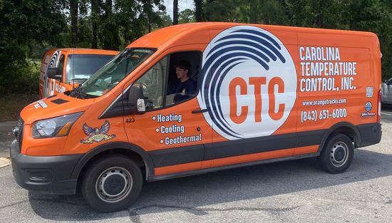 Orange service truck that has the words heating, cooling, and geothermal on it.