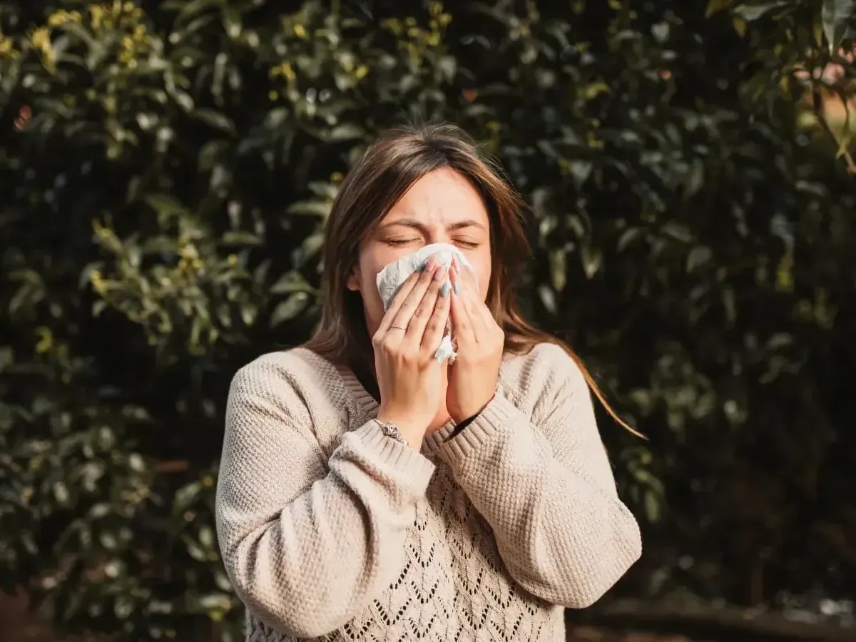 Woman with allergies blowing her nose