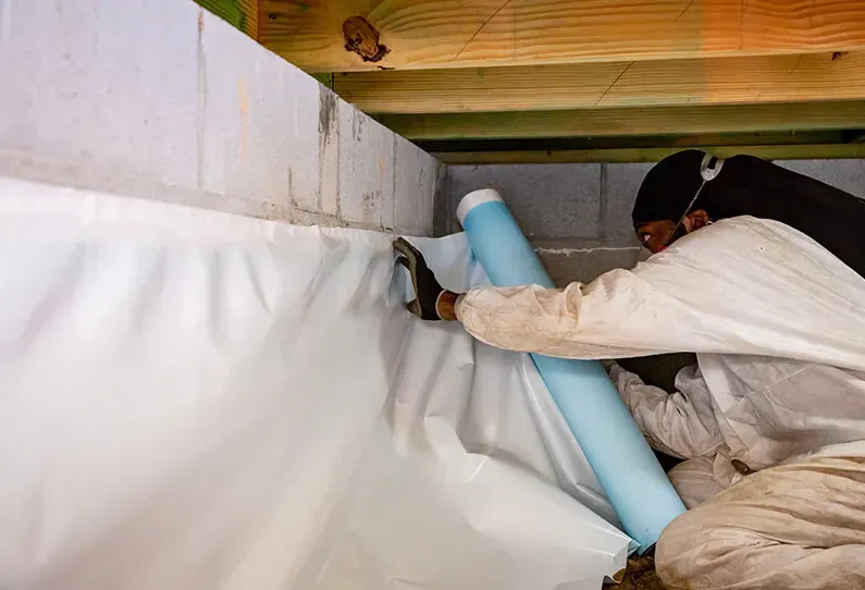 Technician installing a crawlspace liner