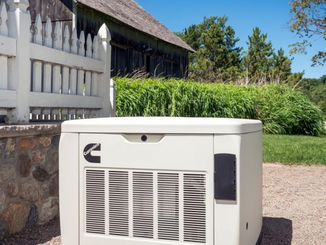 A Cummins standby home generator sitting outside of a home