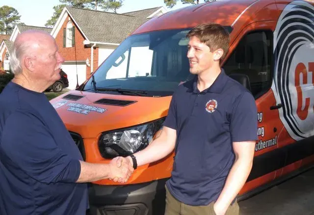 CTC technician greeting a customer CTC technician greeting a customer in front of our signature orange work truck.