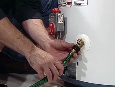 HVAC technician cleaning and repairing a hot water heater