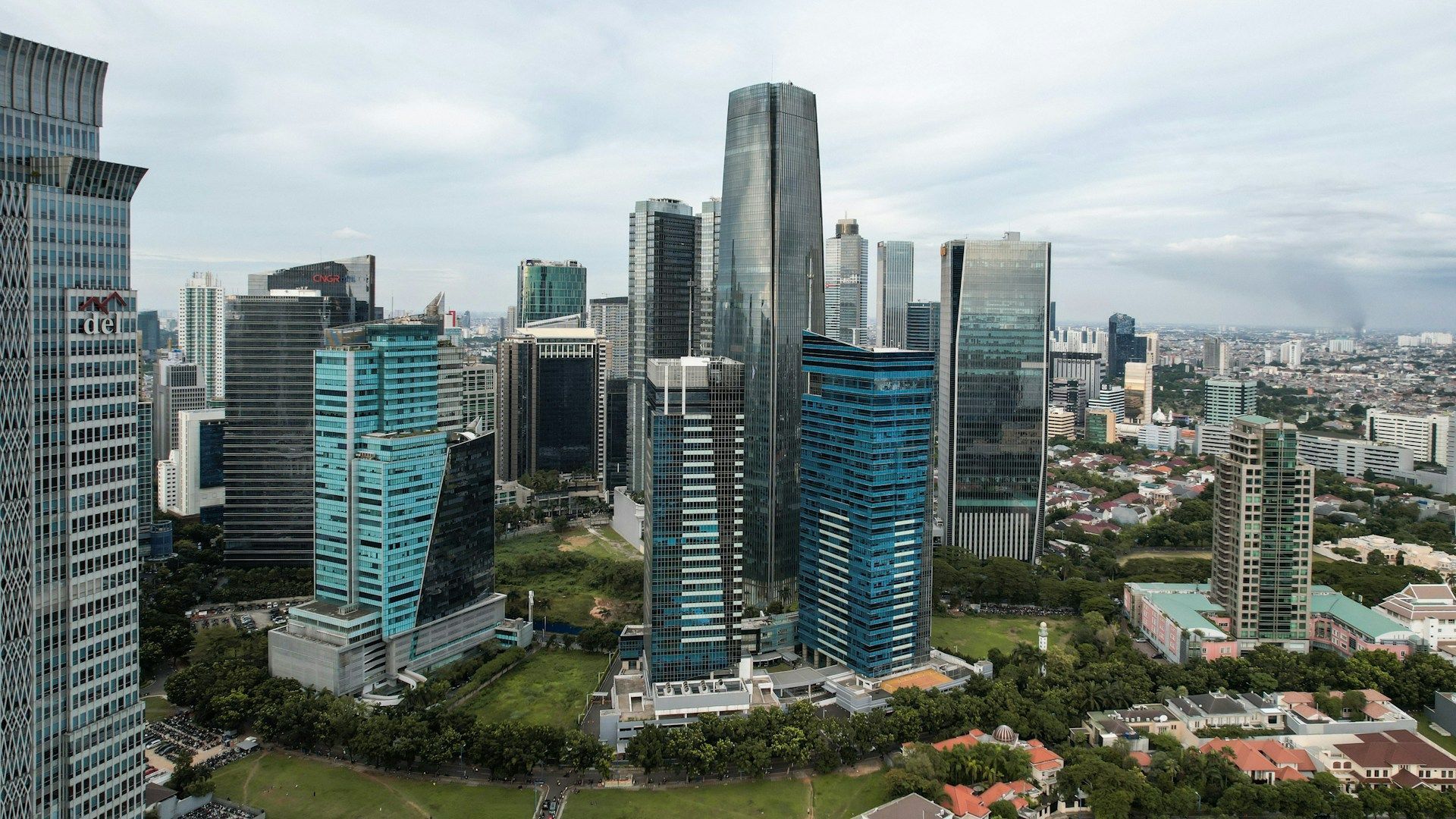 City skyline with many modern skyscrapers and cloudy sky.