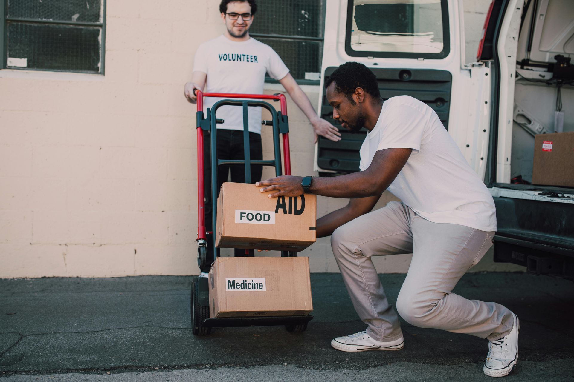 Two people loading boxes labeled 