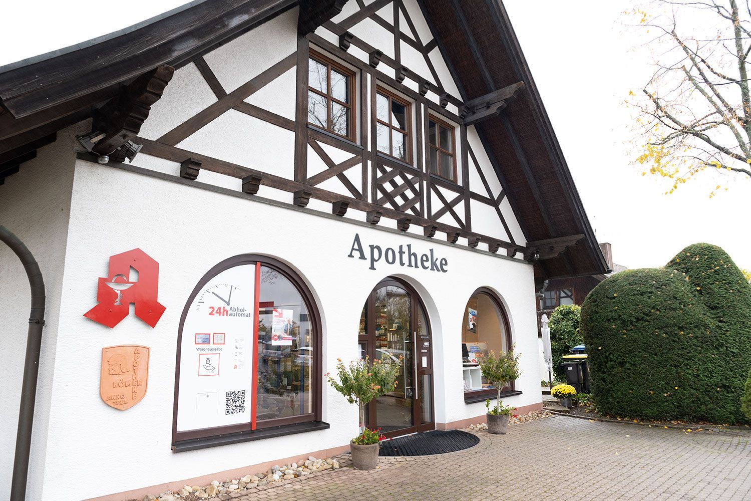 Ein weißes Gebäude mit einem Holzdach und einem Schild mit der Aufschrift „Apotheke“