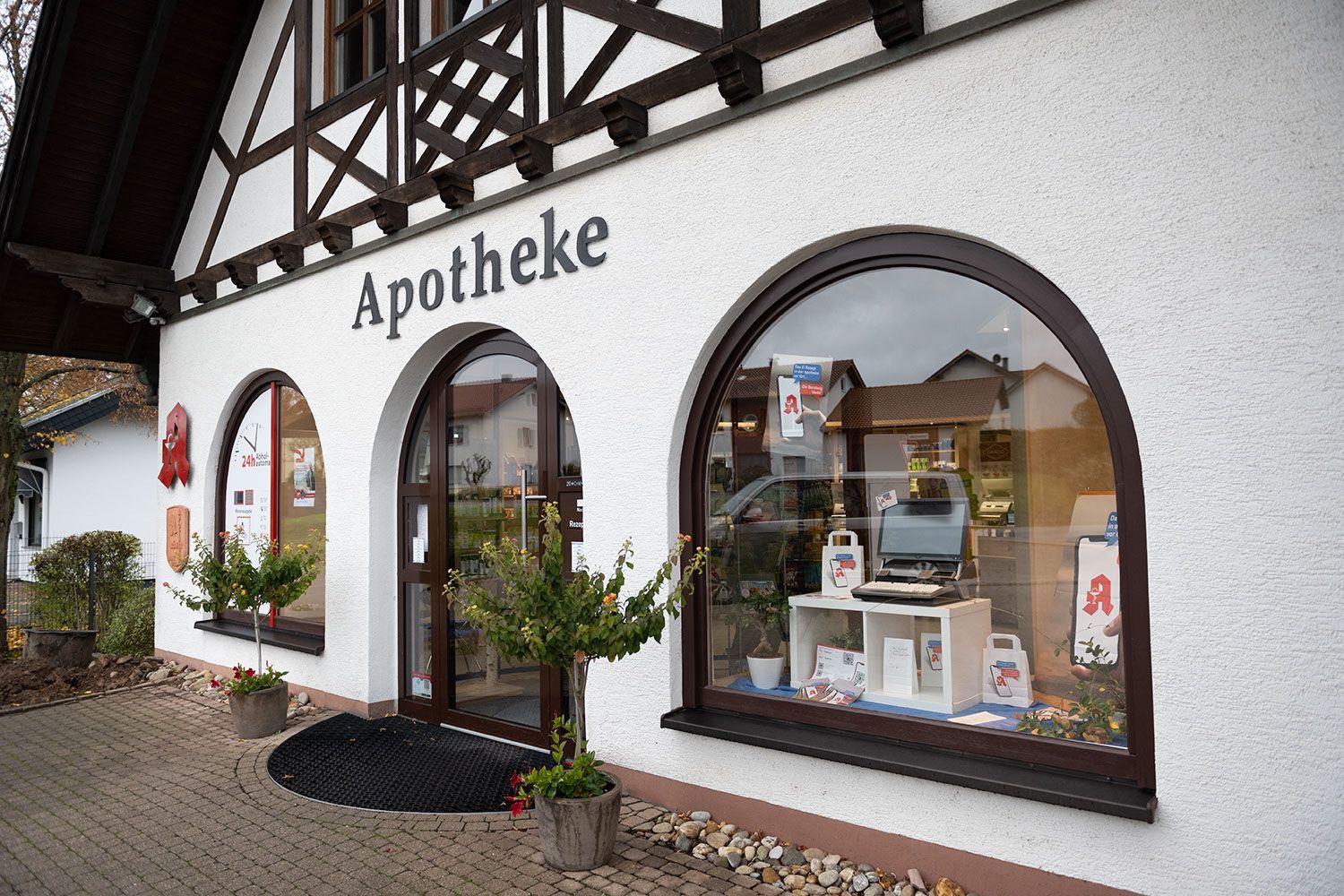 Ein weißes Gebäude mit Bogenfenstern und einem Schild mit der Aufschrift „Apotheke“