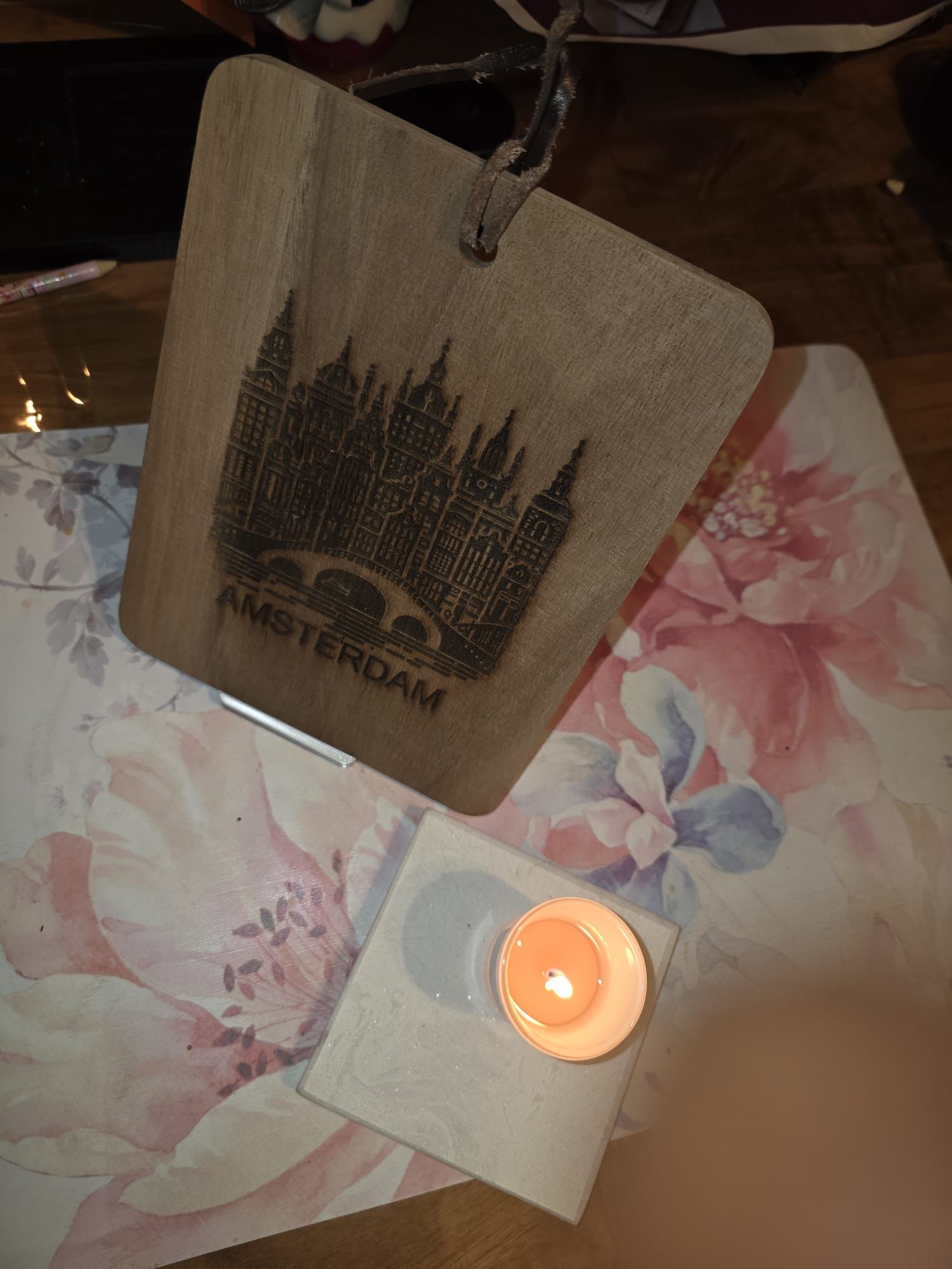 Wooden tag laser-etched with Amsterdam skyline and text, inside a laser engraving machine.