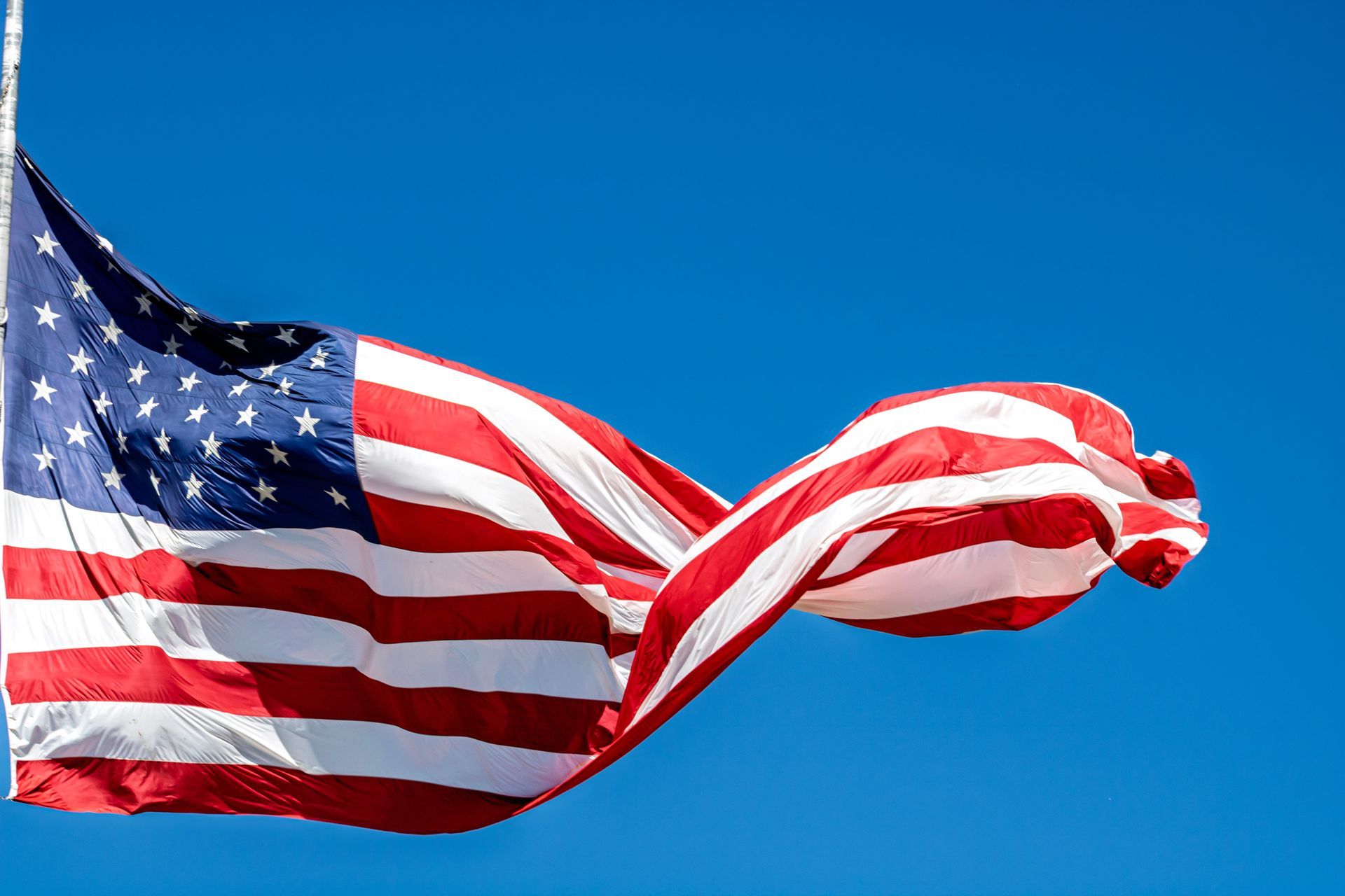 American flag waving against a clear blue sky
